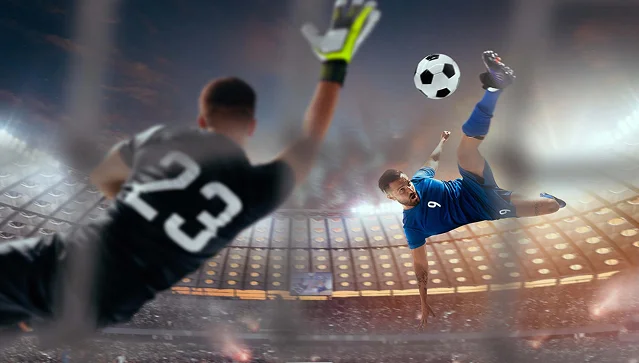 Guarda-redes a mergulhar em direção a uma bola enquanto um jogador adversário executa um pontapé de bicicleta dentro de um estádio cheio